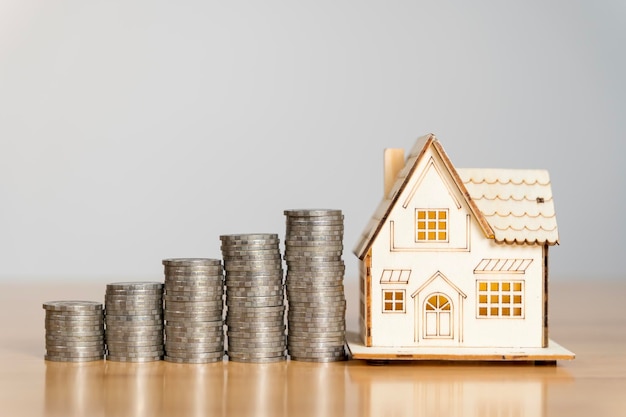 House model and coin money on table for finance and banking concept Saving money concept