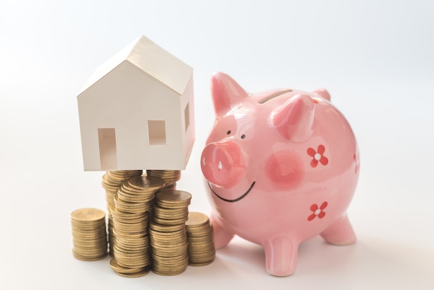 Photo house model on coins stack and piggy bank