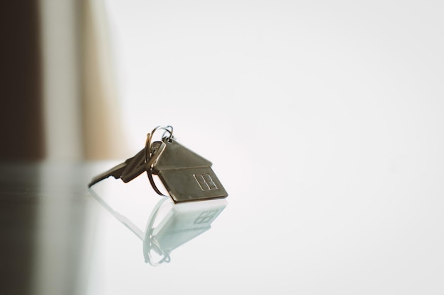 Модель дома и ключ в доме со светом из окна