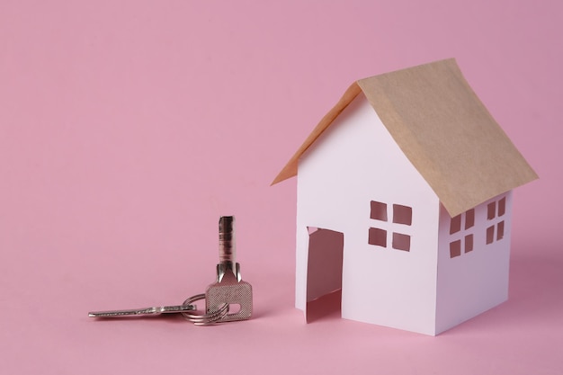 House model and keys on pink background