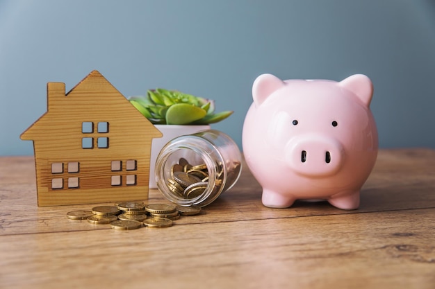 House model with coins and piggy bank