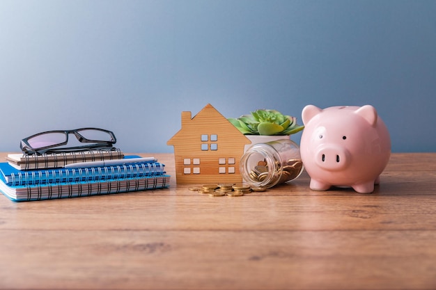 House model with coins and piggy bank