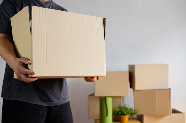 House moving concept Man holding cardboard box closeup