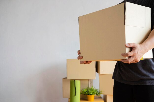 House moving concept Man holding cardboard box