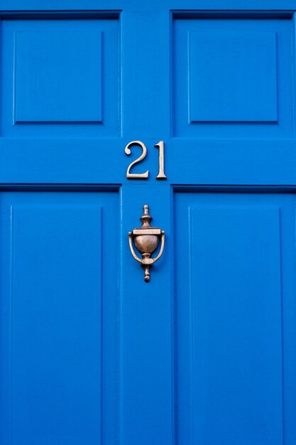 House number 21 on a blue wooden front door in london