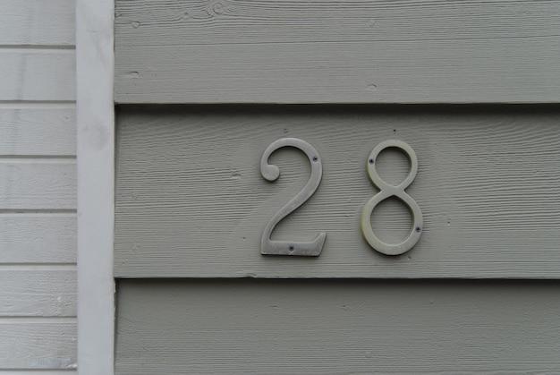 Photo house number 28 sign on green painted wall