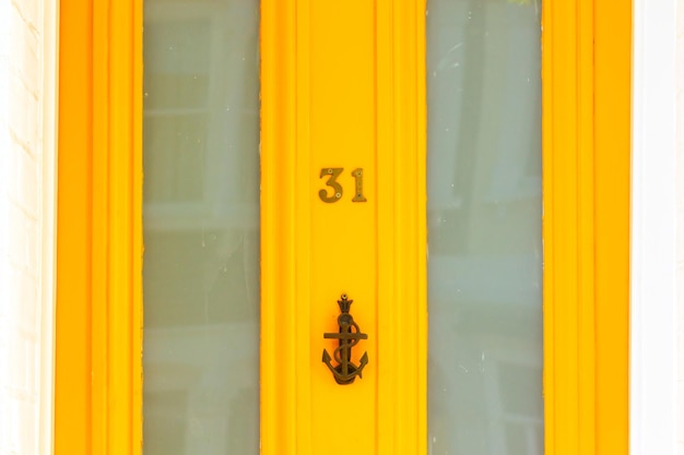 House number 31 on an orange wooden front door in london