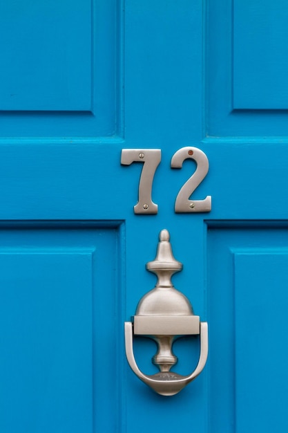 House number 72 on a blue wooden front door in london