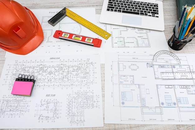 House plan blueprint with repair tools helmet on desk