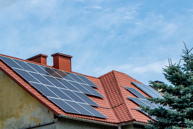 House roof with photovoltaic modules. Historic farm house with modern solar panels on roof and wall