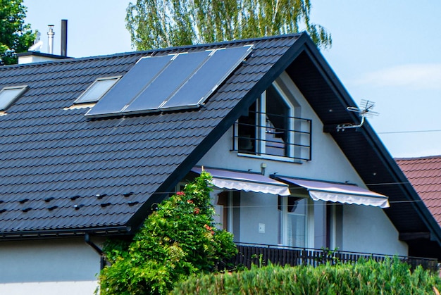 Крыша дома с фотоэлектрическими модулями. Исторический фермерский дом с современными солнечными панелями на крыше и стене