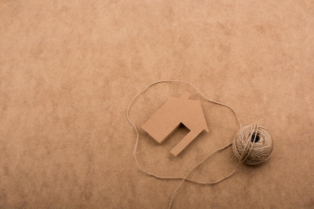 House shape cut out of paper and spool of thread