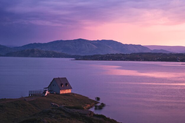 Casa sulla riva del lago al tramonto, bacino idrico di bukhtarma, kazakistan orientale