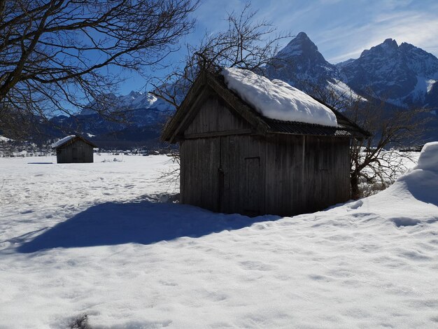 Photo house on snow covered landscape against sky