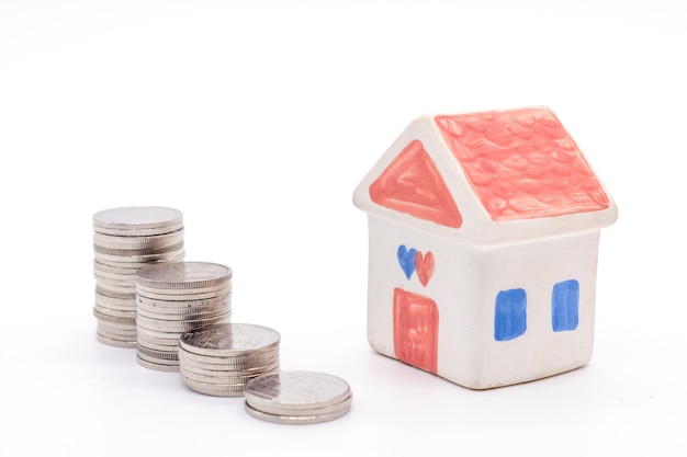 House and stack coins on white background