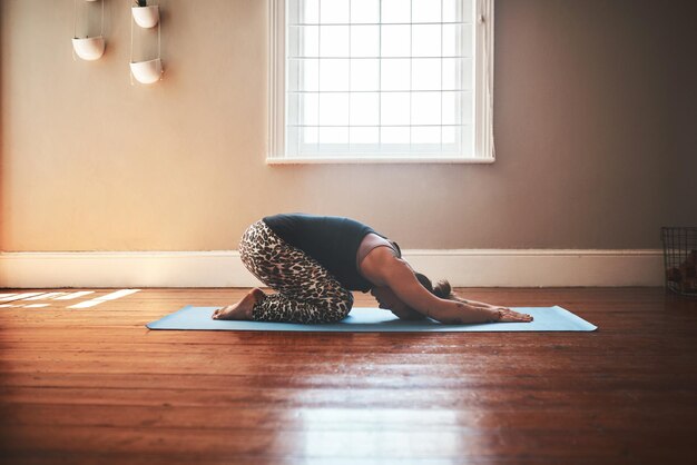 House stretching and woman with yoga meditation and balance with wellness in living room Person apartment and healthy girl with workout chakra and zen with fitness exercise and breathing