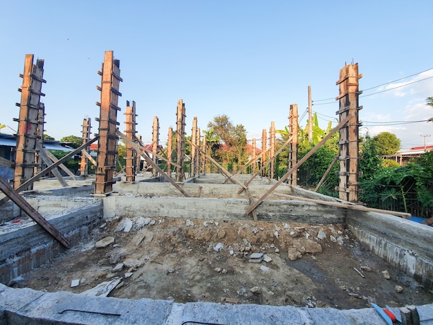 家の構造の建設セメントの床を注ぎ、すでにセメントの柱を注ぎます。その空を背景に。