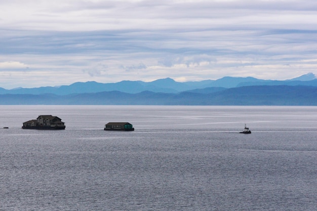 Дом на буксире в море на фоне облачного неба