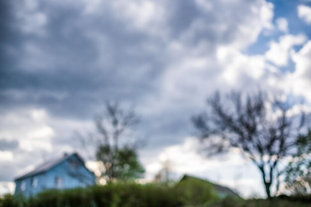 House in the village and cloudy sky Out of focus