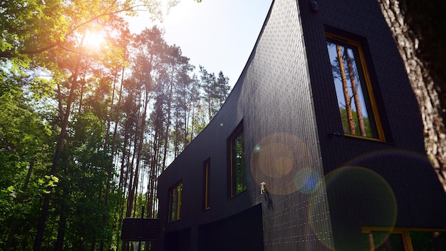 a house with a black exterior and a window that is open to the sun
