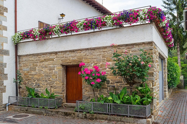 A house with a brick wall and flowers on the roof.