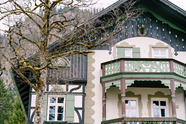ドイツオーバーアマガウの村にある彫刻が施されたバルコニーとシャッター付きの家