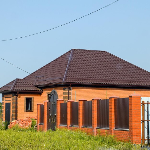 Photo the house with plastic windows and a roof of corrugated sheet