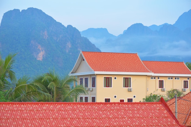 A house with a red roof and mountains in the background