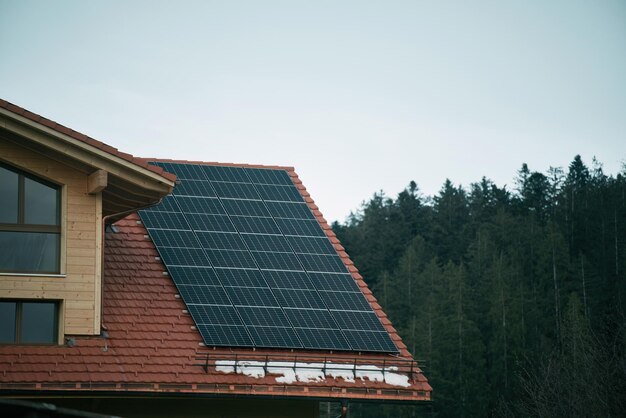 House with solar panels Photovoltaic panels PV on the sky background Blue solar panels An alternative source of electricity