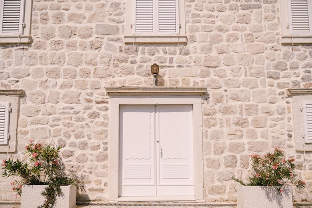 House with a stone facade shutters on the windows and a white door perast montenegro