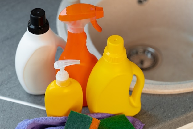 Household chemicals product bottles standing near the kitchen sink