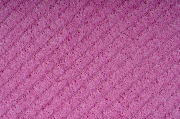 Primo piano delle spugne per la pulizia della casa spugna trama dettaglio spugna trama vicino sfondo cellulosa spugna rossa trama rete metallica rosa su sfondo superficie spugna