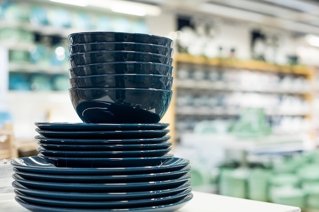 Household items are arranged on the shelves for sale. Plates, cups, bowls, in shades of classic blue.Blue plates and dishes, modern design.ceramic dishes.modern home decor furnishings store.