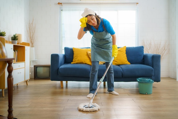 写真 リビング の 床 を 掃除 し て いる 家政婦 が 疲れ て い ます