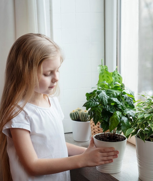 Houseplant care, little girl caring for houseplants