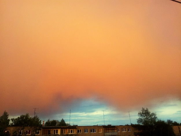 Houses against orange cloudy sky