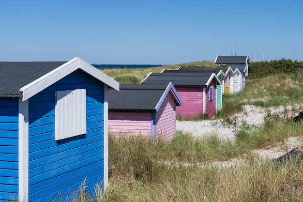 Houses on beach by sea against clear blue sky