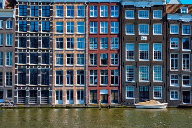 houses and boat on Amsterdam canal Damrak with reflection. Ams