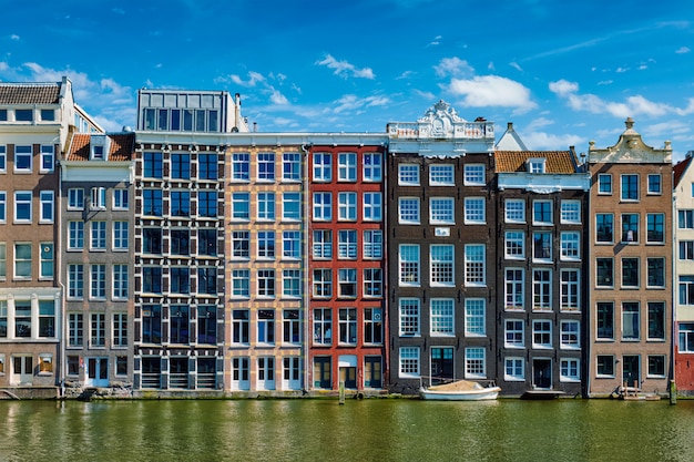 住宅と反射とアムステルダム運河ダムラックのボート。 Ams