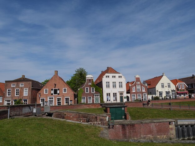 Houses by buildings in town against sky