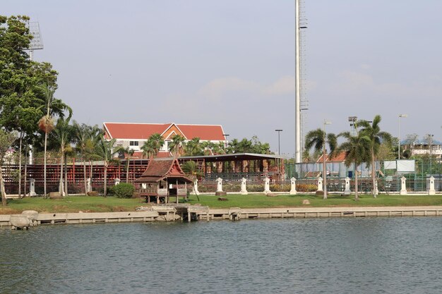 Houses by lake against buildings in city against sky