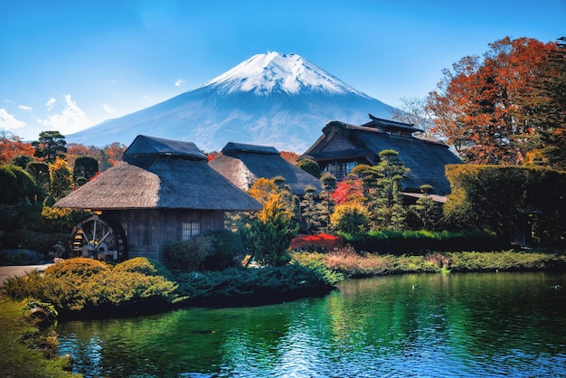 雪に覆われた富士山の向こうの湖の近くの家