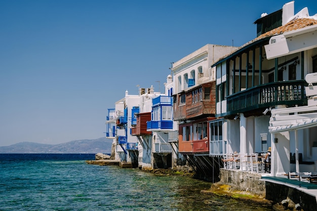 houses by sea against clear blue sky