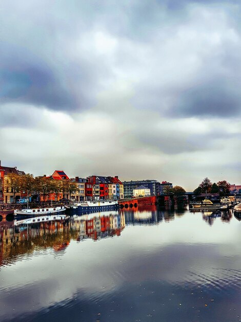 Photo houses by sea against sky in town