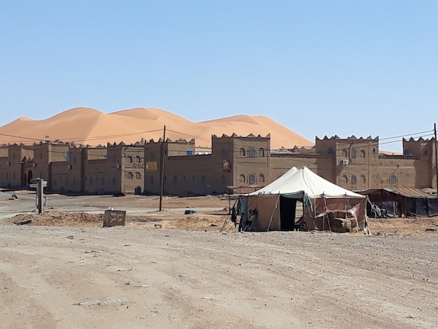 Houses on desert against clear blue sky