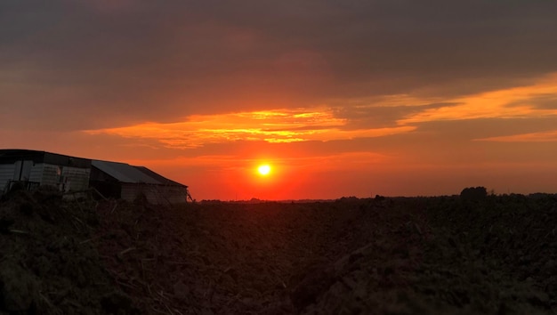 Foto case sul campo contro il cielo durante il tramonto