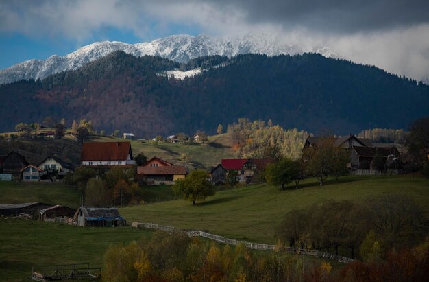 Houses on field by mountain against sky