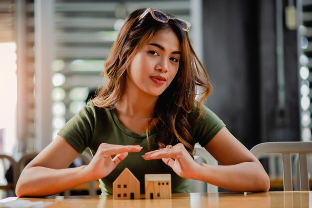 アジアの女性と木製の家 モデルの最初の家 プロジェクトと住宅ローン