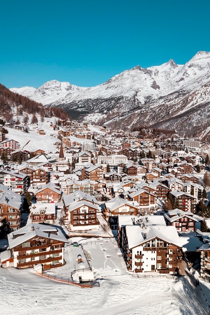 写真 空に照らされた雪に覆われた山の家