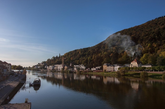 Foto case sulla riva del fiume da montagna di alberi contro il cielo